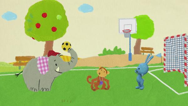 Kikaninchen, ein Elefant und ein Affe spielen Ball