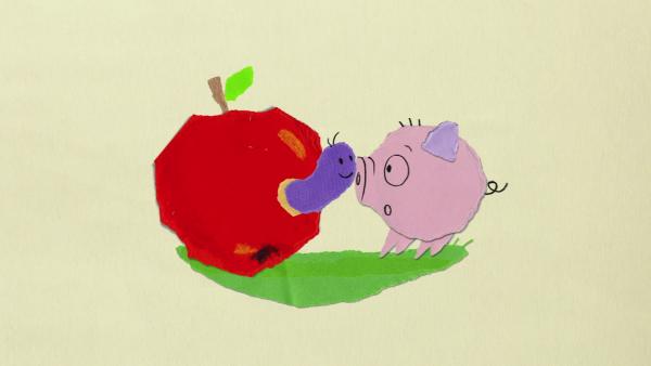 Ein Wurm schaut aus einem roten Apfel und erschreckt ein kleines Ferkel.