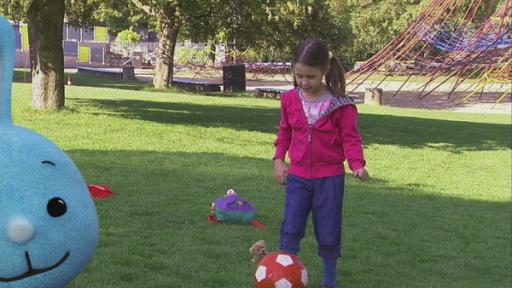 Kikaninchen spielt mit einem kleinen Mädchen Fußball.