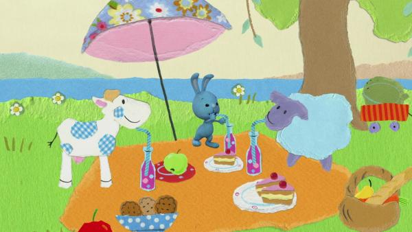 Kikaninchen, eine Kuh und ein Schaf machen ein Picknick.