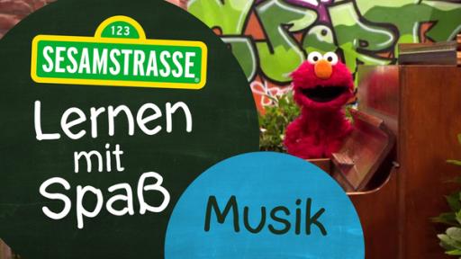 Elmo steht vor einer Wand mit Graffiti und hinter einem braunen Klavier. Neben ihm steht ein Schild auf dem steht: "Sesamstraße: Lernen mit Spaß - Musik".