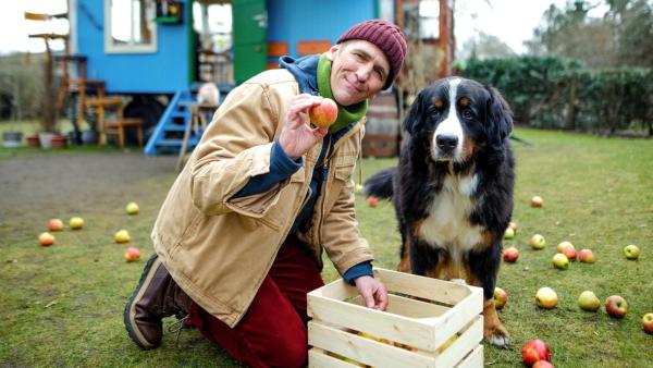 Fritz hockt mit Keks vor dem Bauwagen und hält einen Apfel in der Hand | Rechte: ZDF