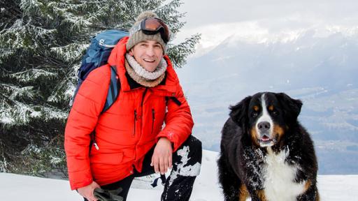 Fritz Fuchs und Keks stehen in den Bergen im Schnee