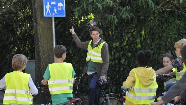 Lehrer Kees (Leendert de Ridder, M.) erklärt seiner Klasse ein Straßenschild. Er bereitet die Schüler auf die Fahrradprüfung vor. | Rechte: ZDF/PVP Pictures/Jaap Vrenegoor