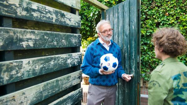 Herr van Eik (Flip Filz, l.) gibt Fred (Tygo Desmet, r.) seinen Fußball zurück, nachdem der Ball aus Versehen beim Kicken auf seinem Grundstück gelandet ist. Verärgert gibt der Nachbar Fred dabei zu verstehen, dass er ein solches Missgeschick nicht noch einmal dulden wird. | Rechte: ZDF/PV Fiction/Jaap Vrenegoor
