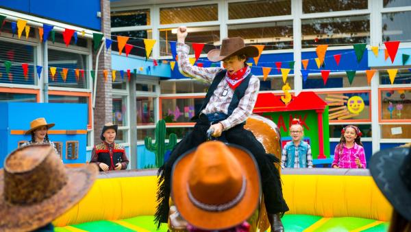 Fred (Tygo Desmet, Mi.) zeigt seinen Klassenkameraden, wie man sich lange auf dem Rodeo-Bullen halten kann, aber auch, wie man am geschicktesten herunterfällt ohne sich zu verletzen. | Rechte: ZDF/PV Fiction/Jaap Vrenegoor