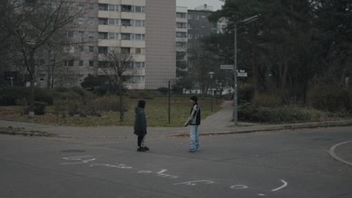 Yussuf (Shadi Eck, rechts) und Elif (Safinaz Sattar) stehen beim Schriftzug auf der Straße.