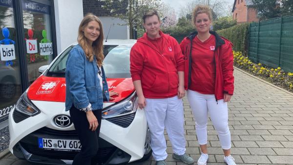 Reporterin Jana steht mit Luca und Denise vor einem Auto. | Rechte: WDR/tvision