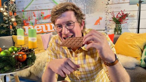 Neuneinhalb-Reporter Robert beißt in eine Tafel Schokolade.