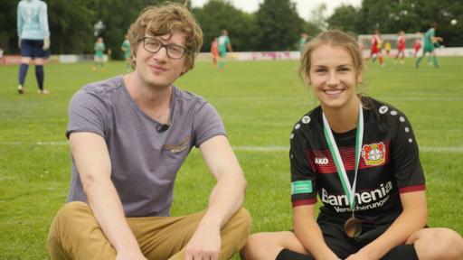 Robert und Pauline sitzen auf dem Fußballfeld