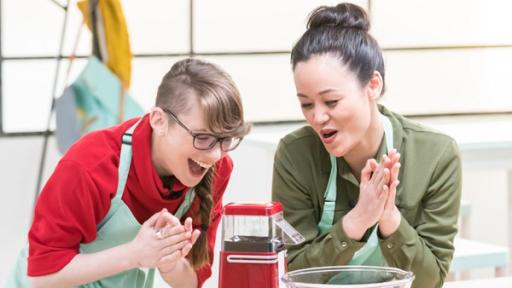 Patrizia (li.) und Linh (re.) freuen sich  über die funktionierende Popcornmaschine (mi.).