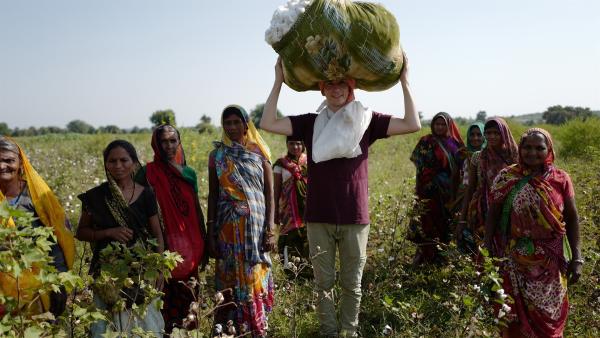 "pur+"-Moderator Eric Mayer hat indischen Pflückerinnen geholfen. Auf dem Kopf balanciert er die Ernte von 3 Stunden. Die Baumwolle reicht für 25 T-Shirts. | Rechte: ZDF/Zeljko Pehar