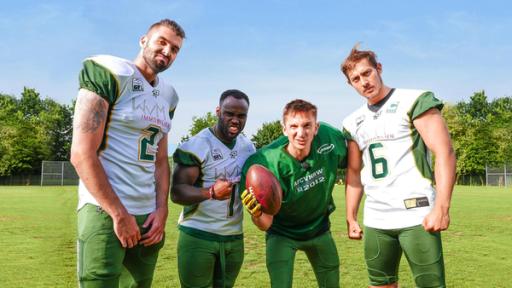 Moderator Eric Mayer in einer Trainingspause zusammen mit drei American Football Spielern der Cologne Crocodiles.