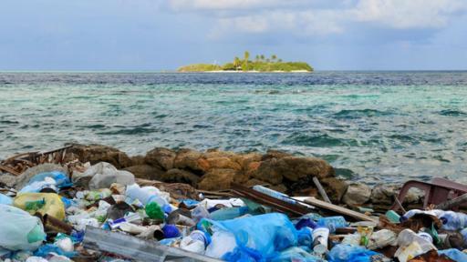 Kunststoffmüll im Meer vor einer Insel