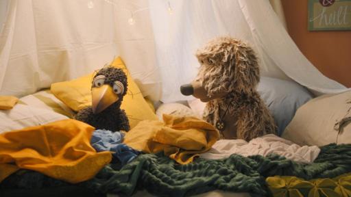 Rabe Rudi (rechts) sitzt mit Hund Buffo (links) in der gemütlichen Kuschelecke.