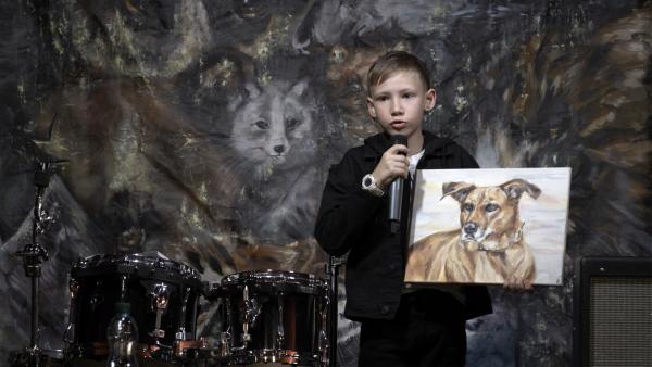 Pavel auf der Bühne des Tierrechte-Rock-Festivals bei der Versteigerung seines Gemäldes für wohltätige „Tier-Zwecke“ | Rechte: SWR/Telekult Film- und Medienproduktion/Sergei Amirdzhanov