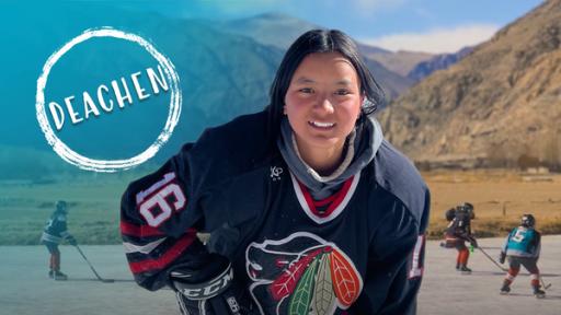 Mädchen spielt Eishockey vor Bergkulisse