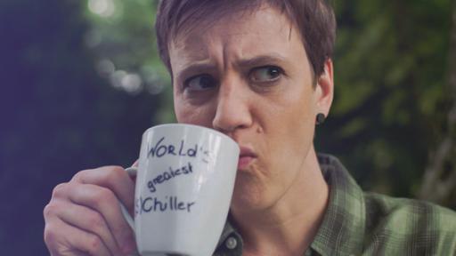 Eine Person trinkt aus einer Tasse.