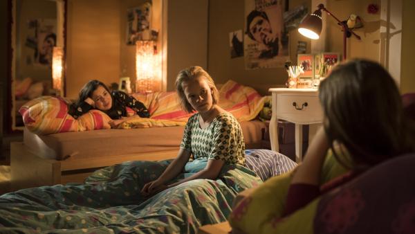 Martha sitzt auf dem Bett und schaut ihre beiden Freundinnen an die links und rechts neben ihr im bett liegen.  | Rechte: MDR/Saxonia Media/Felix Abraham