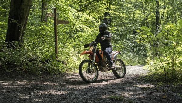 Ein Motorradfahrer braust durch den Wald und bemerkt nicht, wie er eine wichtige Spur verwischt. | Rechte: MDR/Saxonia Media/Felix Abraham