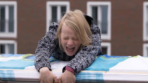 Beim Versuch, ein großes Plakat von einem Hausdach hängen zu lassen, gerät Martha (Luna Kuse) in große Gefahr. | Rechte: MDR/Saxonia Media/Katharina Simmet