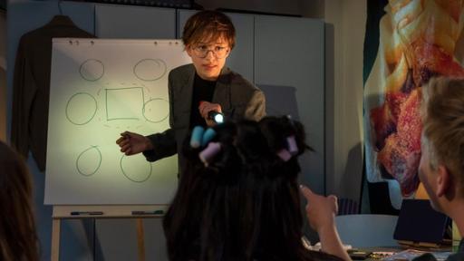 Ein Junge steht am einem Flipchart und erklärt etwas.