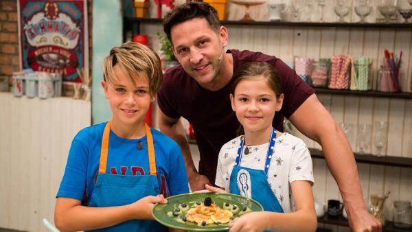 Fabian, Alex und Hannah präsentieren stolz gebackene Milchplätzchen in Kokosflocken mit Früchten. | Rechte: ZDF/Rothkopf Rene