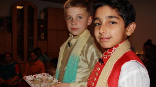 zwei Jungen in Tracht servieren Gebäck