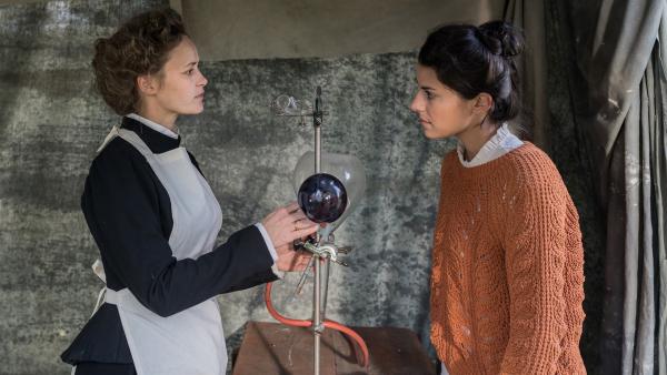 Marie Curie (Inez Bjørg David, li.) erzählt Clarissa (re.) von ihren mobilen Röntgengeräten. | Rechte: KiKA/Sabine Finger