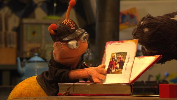 Finchen leiht sich von Wolle und Pferd das tolle Märchenbuch, das sie immer zum Einschlafen lesen. | Rechte: NDR/Sesame Workshop