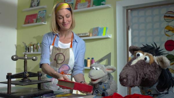 Julia hilft Wolle und Pferd dabei, das geliehene Buch zu reparieren. | Rechte: NDR/Sesame Workshop