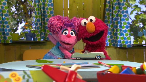 Das pinke Monster Mädchen Abby links umarmt den roten Monster Jungen Elmo rechts | Rechte: NDR