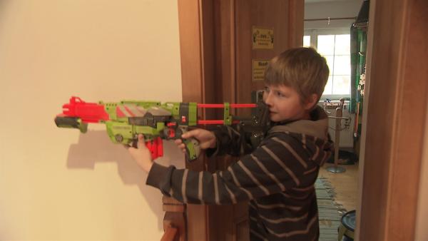 Matej ist mit einem Spielzeuggewehr auf Verfolgungsjagd nach seinem Bruder. | Rechte: ZDF/Filip Majer