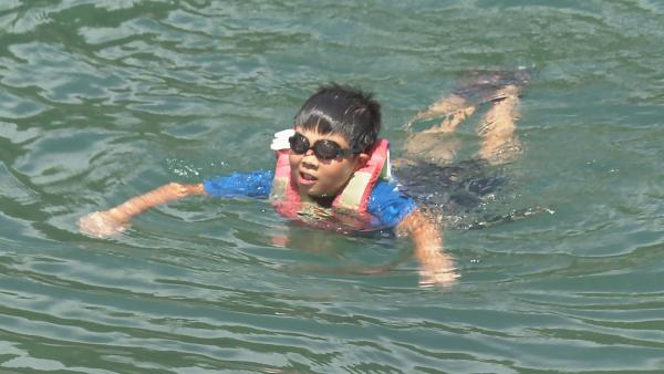 Kenshi, der ein Muscheltaucher werden möchte, muss zunächst schwimmen lernen. Mit großer Angst und Schwimmweste wagt er sich ins Wasser. | Rechte: ZDF/Toru Suzuki
