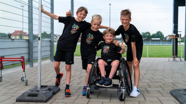 Theo (3.v.l.) und seine Freunde sind ein gutes Team. Gemeinsam starten sie ein Zehn-Kilometer-Rennen. Dass Theo die Strecke im Rollstuhl zurücklegt, weil er die seltene Glasknochen-Krankheit hat, hält die Jungs nicht auf. | Rechte: ZDF/Florian Lippke