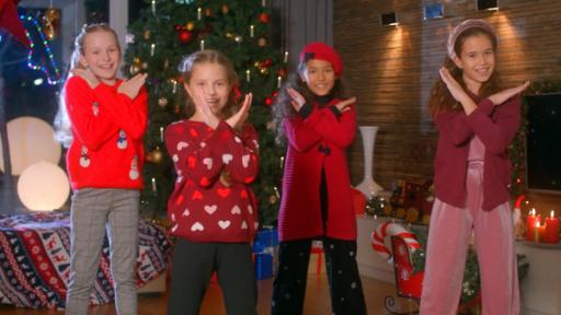 Viktoria, Nika, Laura und Sophia stehen vor einem geschmückten Weihnachtsbaum und singen ihren Weihnachtssong.