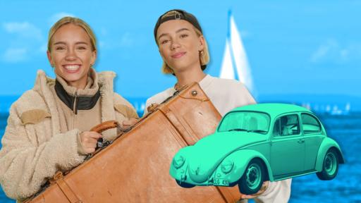 Lisa und Lena mit Reisekoffer neben einem VW-Käfer