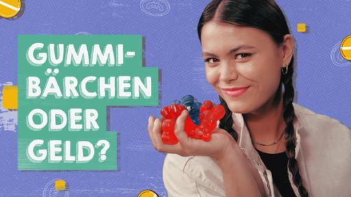 Junge Frau hält große Gummitiere in der Hand und fragt: Gummibärchen oder Geld? 