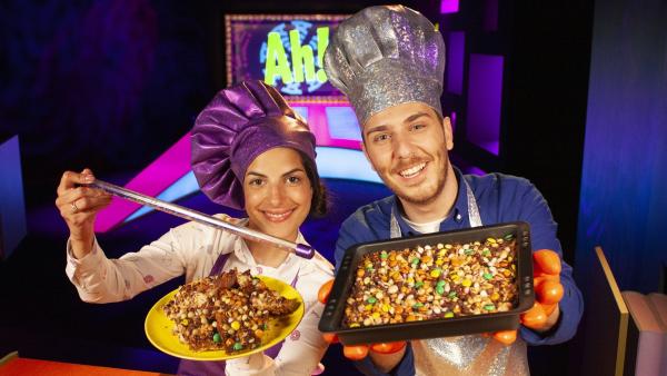 Clarissa und Tarkan nehmen ihre Zuschauer mit zu einer magischen Küchen-Show. Anstelle eines  Show-Outfits werfen die beiden sich glitzernde Kochschürzen über und zaubern köstliche Magic Cookies – magische Kekse. | Rechte: WDR/Thorsten Schneider