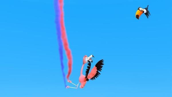 Flamingomädchen Flora (Mitte) fliegt durch die Lüfte und hält dabei mit ihren Füßen zwei Behälter mit Farbe, die einen rosanen und einen lilanen Streifen in die Luft sprühen. Tukan Toni (rechts) fliegt entschlossen auf sie zu. | Rechte: ZDF/ Grid Animation