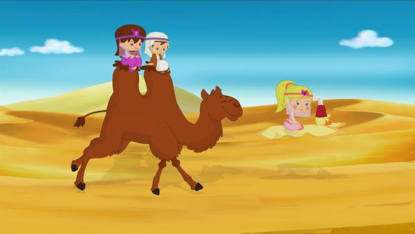 Lili und Max reiten auf Kamel Asif. Zoé fliegt mit ihrme fleigenden Teppich QuackQuack voraus. | Rechte: KiKA/Mike Young Productions